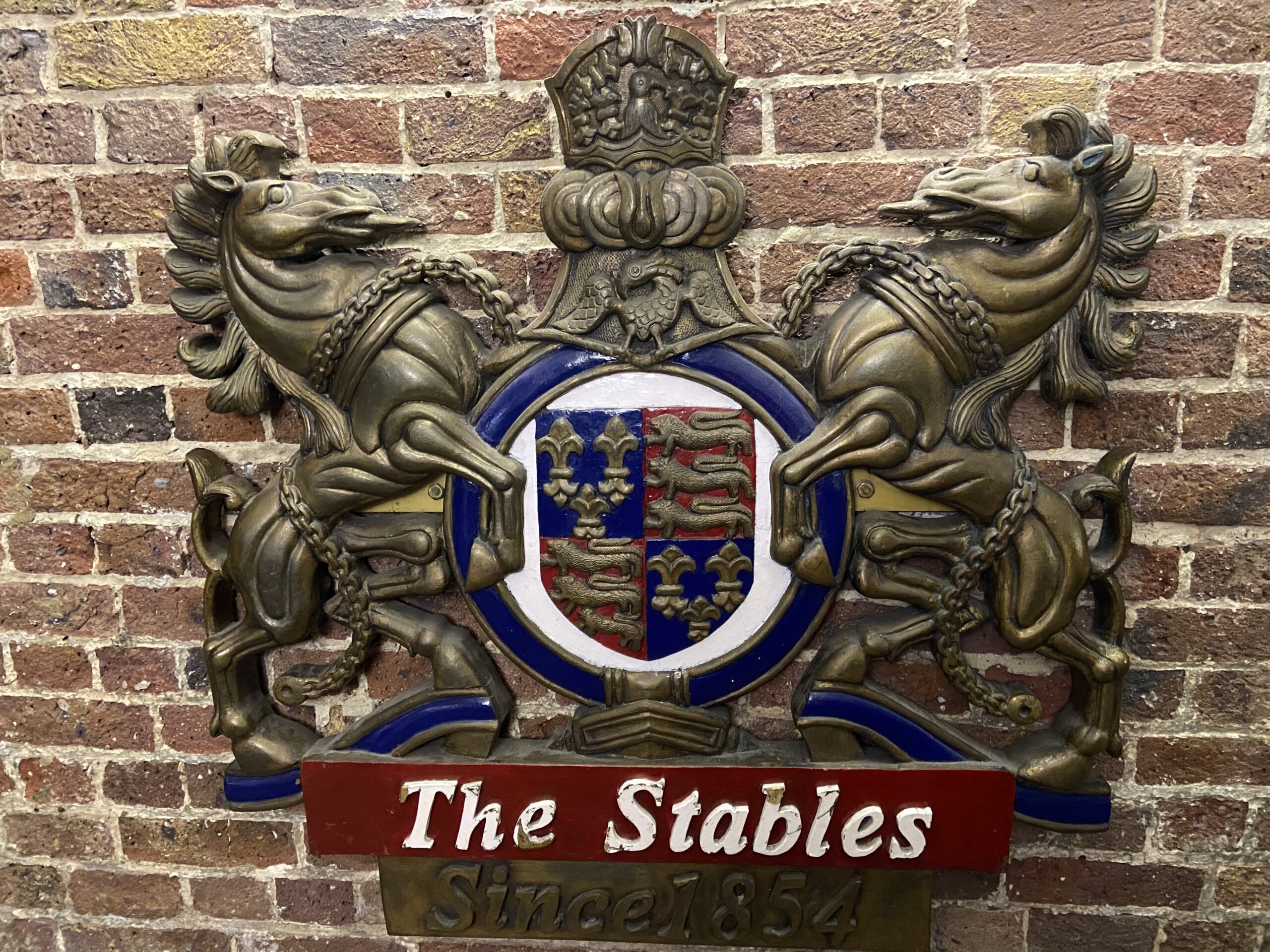 Het wapenschild van The Stables Market Camden met twee paarden en het opschrift Since 1854