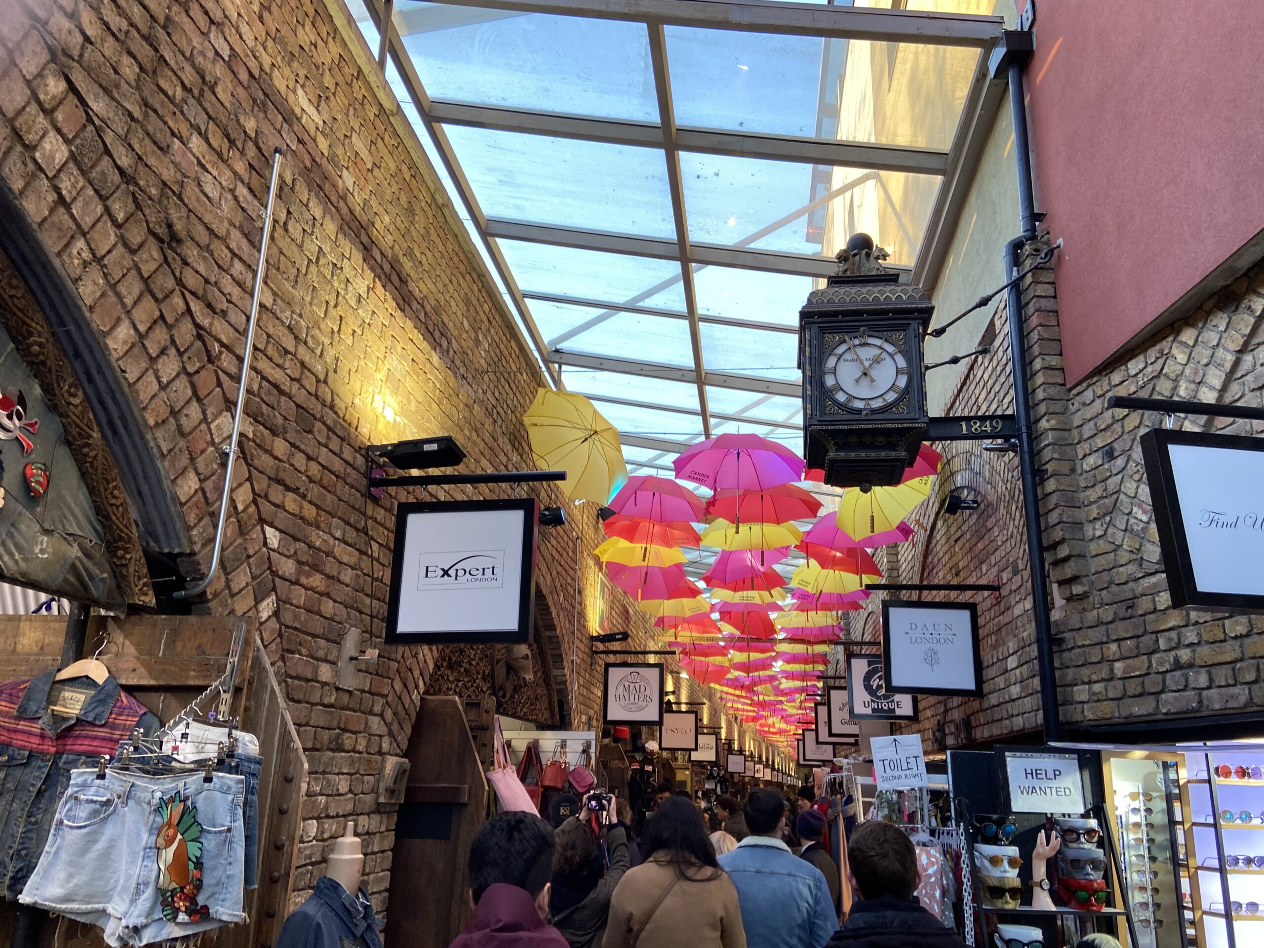 Overdekte passage in Camden Market met kleurrijke paraplu's en een victoriaanse klok uit 1849