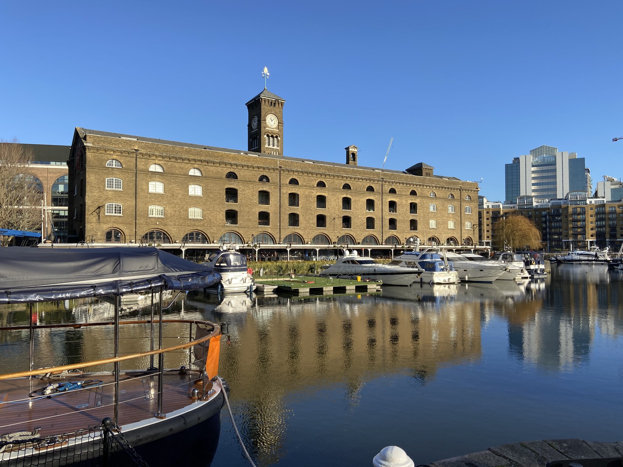 St Katharine Docks marina naast de Tower of London met jachten en Victoriaanse pakhuizen op een zonnige winterdag