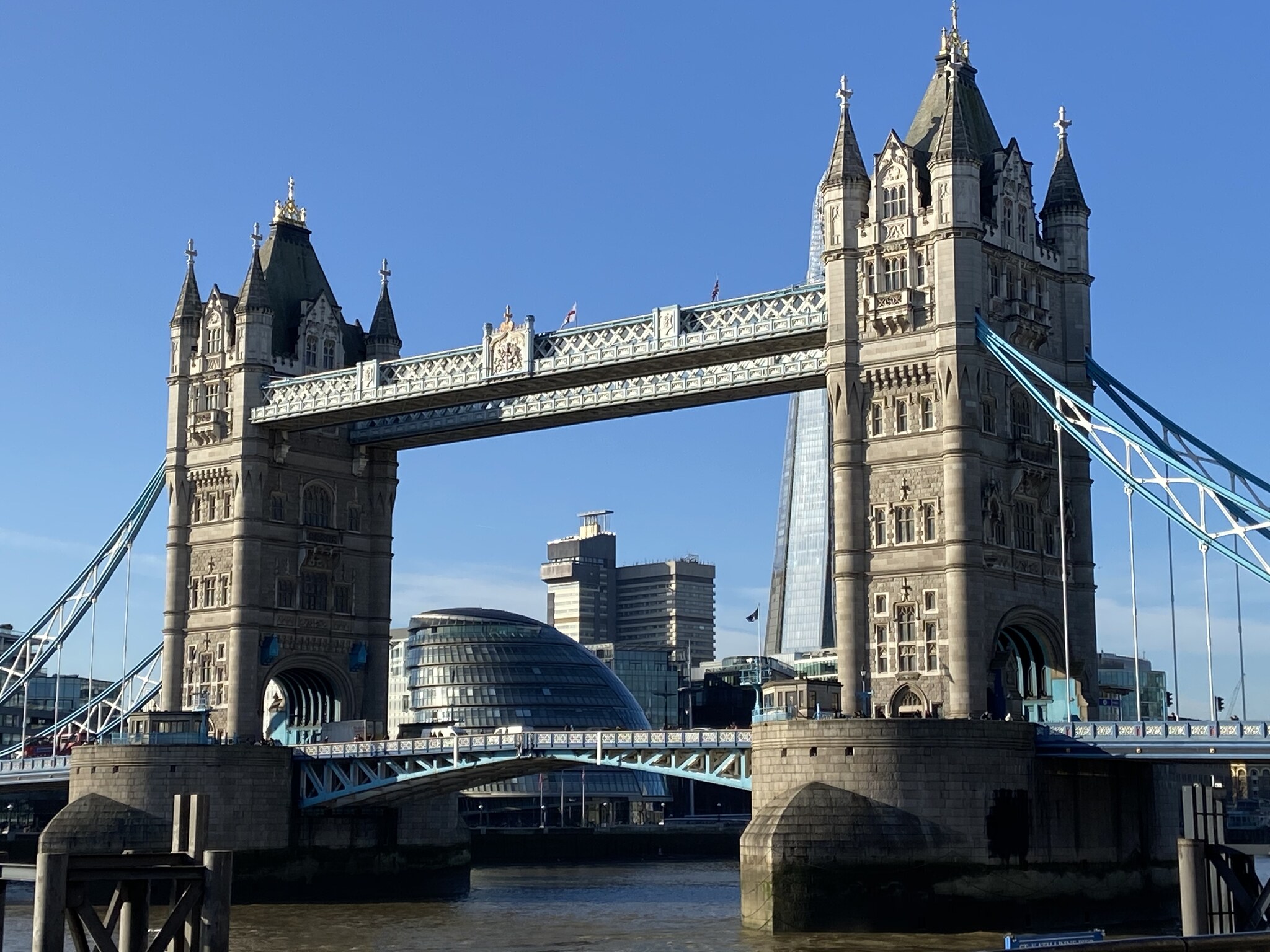 Tower Bridge met The Shard en City Hall zichtbaar door de boog, gezien vanuit de Thames Path bij de Tower of London