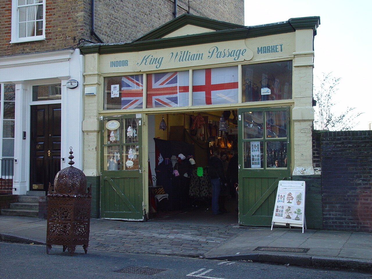Een charmante lokale winkel in Greenwich met Union Jack en St George's Cross vlaggen boven de deur