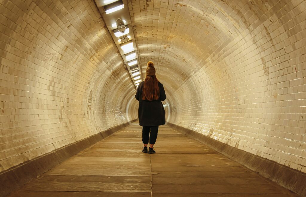 Een wandelaar in de betegelde Greenwich Foot Tunnel